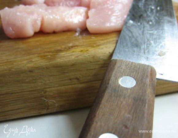 Куриную грудку от делить от остова (если вы покупали не филе) и нарезать кусочками довольно крупно. Посыпать солью и перцем и перемешать как следует на разделочной доске. После чего выложить нарезанное филе в заранее вылитый в миску кефир. Оставить при комнатной температуре не менее 20 минут.