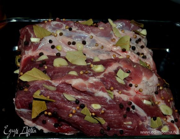 Выложить кусок свинины в жаропрочное блюдо.Нашпиговать кусок свинины чесноком по всему куску. Затем в разрезы поместить черный перец горошком и кориандр горошком. Вдоль куска вставить пластинки моркови,кусочки лаврового листа.
Натереть поверхность свинины красным жгучим перцем, солью и мускатным орехом.