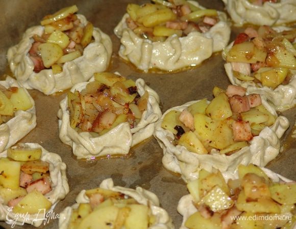 Сформовать из теста колбаску и нарезать одинаковыми кусочками. Из теста получается 12 порций. Каждый кусочек раскатать в круглую лепешку,  диаметром около 15 см. Чем тоньше, тем лучше. В центр выложить начинку, не доходя 1 см до края. Загнуть края теста вверх и защипнуть края, чтобы пирожок держал форму. Если начинка получилась жидкая - сперва защипываем края, потом выкладываем начинку. (Как вариант, если тесто плохо держит форму - выпекать в формочках для кексов.) 