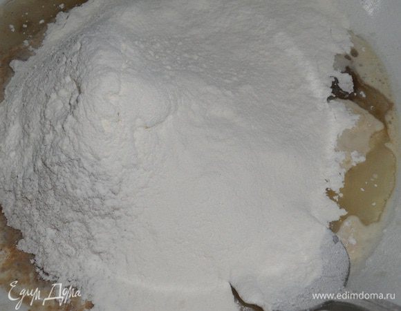 Добавить пшеничную муку и замешивать небольшими движениями тесто.