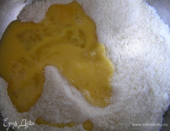 Приготовить бисквит Джоконда. В емкость для взбивания выложить миндальную муку и сахарную пудру (55г), влить половину яиц и взбивать 6-8 минут.
