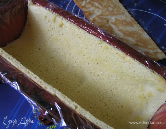 Сборка. Форму для десерта (у меня 23х9,5х5,5см) застелить пищевой пленкой. Бисквит обрезать по краям, отрезать 2/3 по ширине (у меня 17см)и выложить в форму.