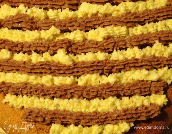 Нанести оставшейся крем кондитерским мешком  на поверхность торта и украсить апельсиновыми цукатами. 