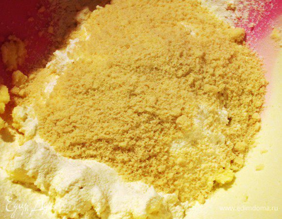 В массу ввести яйцо, просеянную муку, миндальную муку, ванилин, щепотку соды и соли. Тщательно перемешать. 