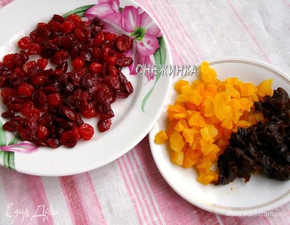 Сухофрукты заливаем горячей водой на минутку, моем, обсушиваем бумажным полотенцем. Чернослив и курагу нарезаем крупным кубиком.