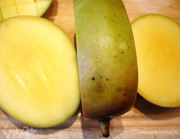Разрезаем манго вдоль косточки с одной и с другой стороны.