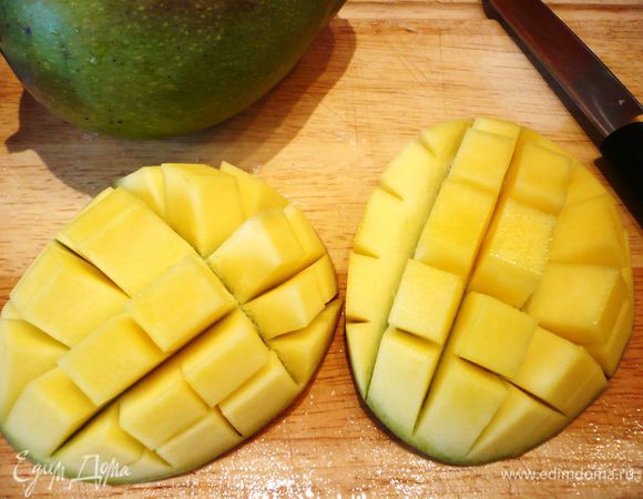Надрезаем мякоть крест-накрест, выворачиваем манго, надавливая на кожуру. Кубики мякоти срезаем. 
