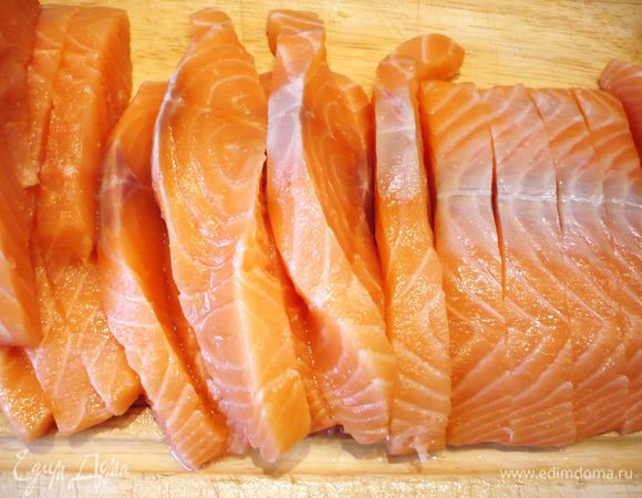 Семгу солим, перчим и сбрызгиваем соком лимона. Режем семгу вдоль примерно на четыре равные части.