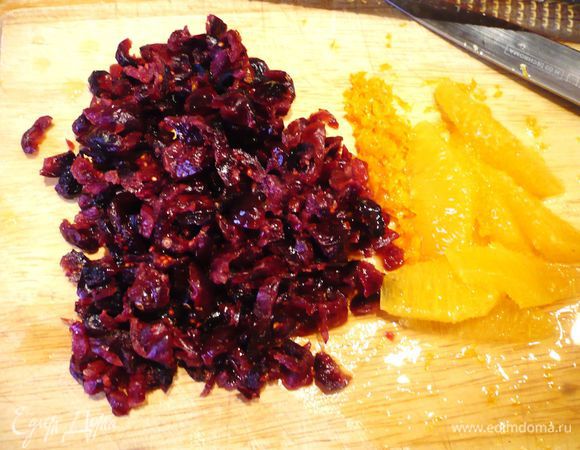 Ставим вариться рис. Бруснику мелко нарезаем, с половинки апельсина снимаем цедру, щедро срезаем корки и освобождаем от пленок мякоть, нарезаем дольки апельсина. 