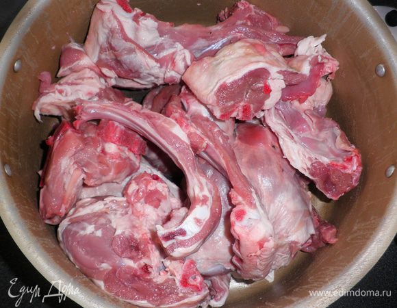 Нарезать мясо барашка на порционные куски и уложить в большую кастрюлю.