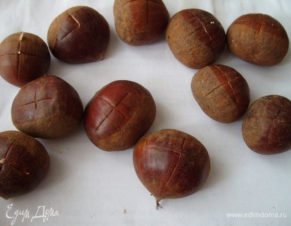 На каштанах сделать надрез, сбрызнуть водой и поставить в разогретую духовку на 20 мин.