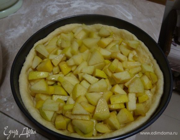 Настоявшиеся яблоки в сахаре выложить аккуратно на тесто ложкой. На дне посуды, в которой были яблоки будет сок, его либо выливать не весь, если много, либо полить сверху выложенные яблоки. Надо следить, чтобы этот сок не вылился сразу на тесто, иначе тесто может размокнуть, лучше попридержать сок, и полить им яблоки сверху.