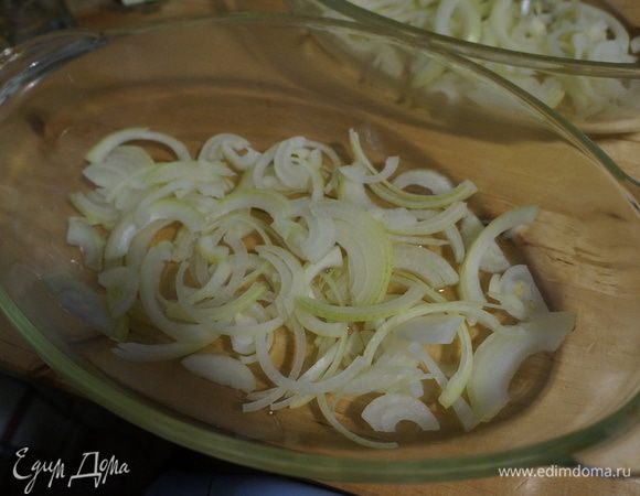 Луковицы нарезать полукольцами, форму для выпечки смазать растительным маслом, на которое выложить луковую подушку
