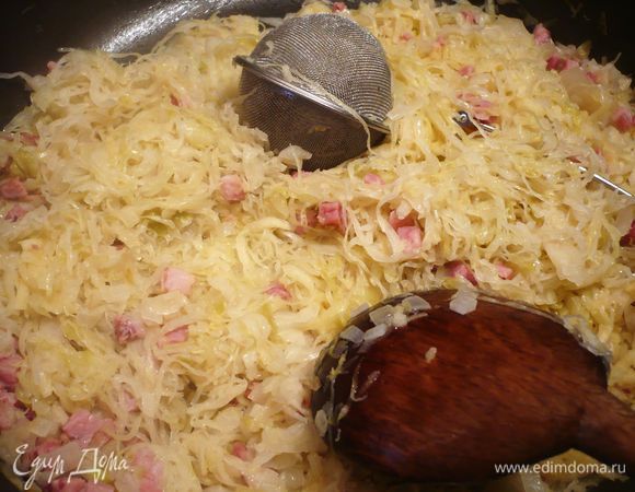 Добавляем капусту, хорошо перемешиваем, кладем яблоки, перемешиваем, затем укладываем нашу ложку с приправами, слегка прикрываем ее капустой, тушим в течение 5 минут, затем кладем примерно 150 г брусники, заливаем бульоном и тушим еще 5 минут. Добавляем сыр, перемешиваем.