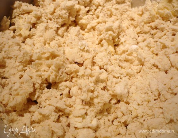 Готовим тесто. Муку с солью смешиваем с маслом в комбайне до образования крошки на низкой скорости, вводим творог и воду. Вымешиваем несколько минут в комбайне, затем перекладываем на присыпанную мукой рабочую поверхность. 