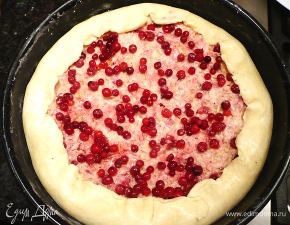 Выкладываем начинку на тесто. Сверху распределяем остальную бруснику. Края теста укладываем на начинку. Смазываем слегка взбитым вилкой белком.
