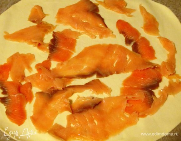 Слоёное тесто раскатать,сверху выложить кусочки лосося....