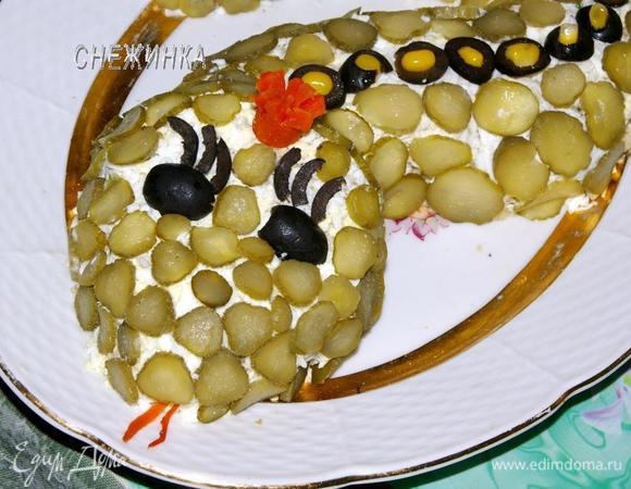 Вырезаем и устанавливаем вначале из маслин глаза и ресницы, из моркови язык и корону. 