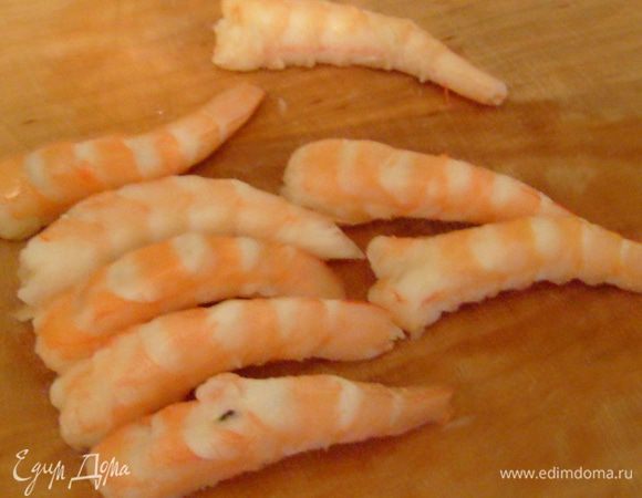 Креветки разморозить, очистить. Головы и панцири не выбрасывать, они пригодятся для соуса. Креветки выложить на разделочную доску спинкой верх и с силой нажать на них пальцами – креветки распрямятся.