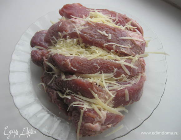 На свинине делаем поперечные, довольно глубокие разрезы и шпигуем натертым на крупной терке сыром. В процессе готовки он полностью растворится, придав свинине дополнительную сочность и аромат.