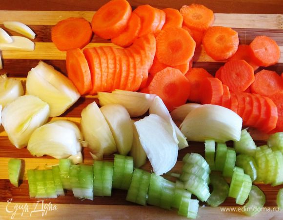 Зубчики чеснока раздавить плоской стороной ножа.Морковь и сельдерей нарезать кружочками. Луковицу разрезать на 4 части. 