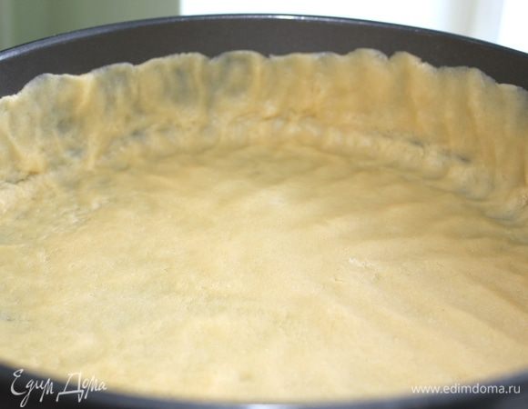 В разъемную форму 24 см (у меня 26) выкладываем тесто, распределяем его руками, делаем бортики
