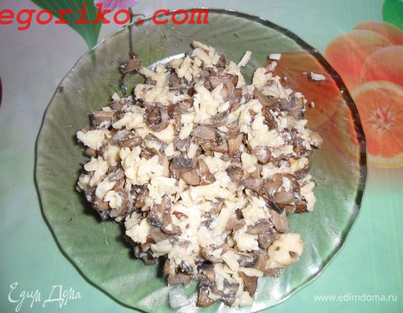 На крупной терке подготавливаем сыр и смешиваем с готовыми шампиньонами.