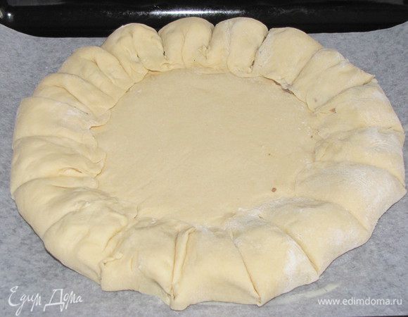 Перенесем пирог на противень, покрытый промасленной бумагой и разрежем валик с начинкой на сегменты.