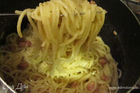 Затем частями добавляем спагетти к соусу, непрерывно и быстро перемешивая. Яичная смесь должна окутать пасту со всех сторон, но не стать омлетом и не пойти хлопьями.