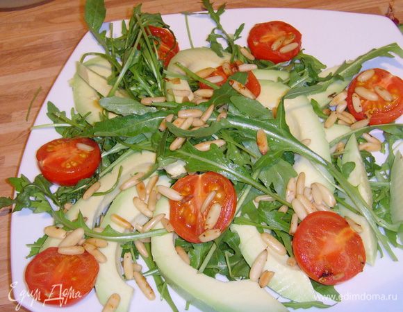 Руколу, мяту и базилик выложить на тарелку. Авокадо очистить, порезать вдоль скибками, выложить на подушку из руколы. Добавить батат и помидоры. Полить дрессингом.