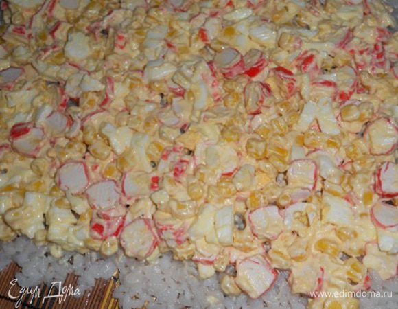 Затем сверху риса слой салата.В  серединку по желанию можно положить полосочками порезанный огурец.