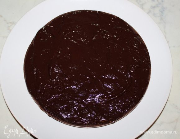 Выложить один корж на блюдо, нанести часть крема.