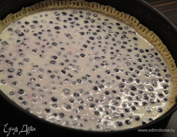 Достаньте форму с охлажденным тестом и вылейте заливку на него. Сверху разложите чернику и отправьте выпекаться в разогретую до 180 градусов духовку на 45 минут.  Достать из духовки и посыпать миндальными лепестками.