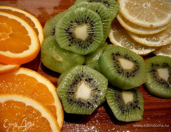 Готовим фрукты в сиропе. Для этого режем на тонкие кружочки апельсины, лимон и на более толстые - киви. 