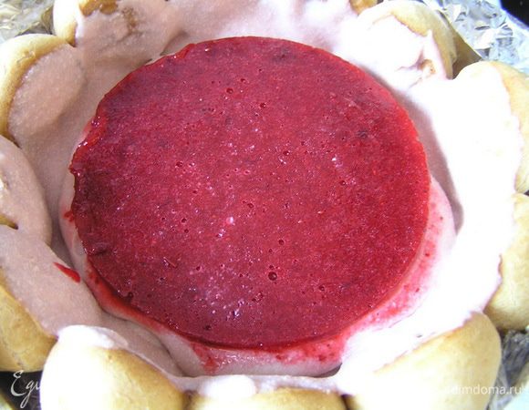 Форму с желе достать из холодильника, опустить на несколько секунд в горячую воду, аккуратно извлечь и выложить поверх застывшего крема в форме с профитролями.