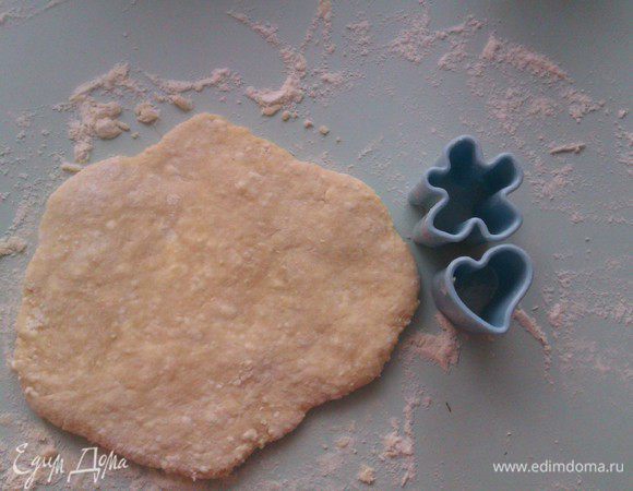 Разделить тесто на несколько частей. Взять 1 часть и  расплющить  ее  руками в лепешку примерно 7-10 мм толщиной.
