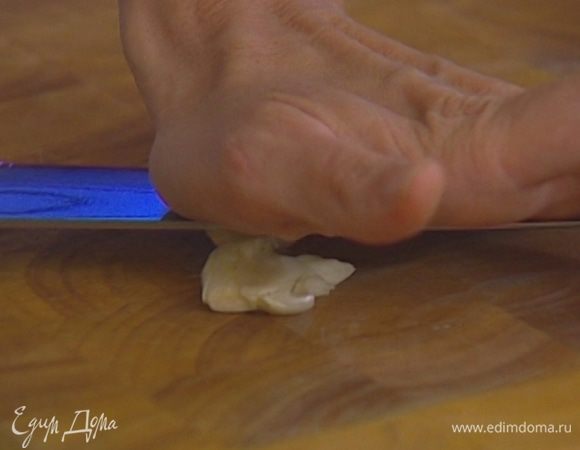 Чеснок почистить и раздавить плоской стороной ножа.