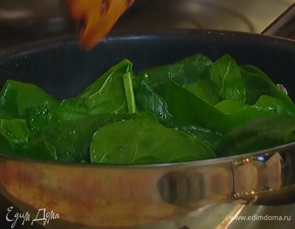 Разогреть в сковороде оставшееся оливковое масло, выложить шпинат и, помешивая, обжаривать 10 секунд, затем выключить огонь, посолить, поперчить, еще раз перемешать и оставить шпинат в сковороде.