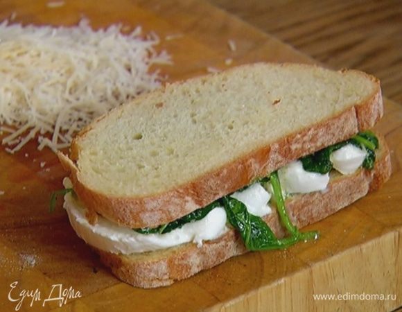 Хлеб с одной стороны смазать соусом песто, на один кусок выложить шпинат, на второй — ломтики моцареллы и сложить оба куска вместе.