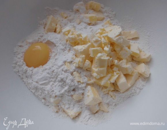 Муку просеять в миску. Добавить масло, нарезанное кусочками, желток и соль. 
