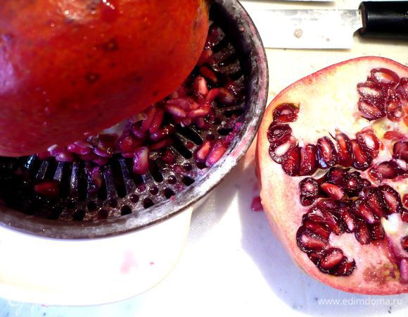 Тем временем два граната разрезаем на две половинки, выдавливаем из них сок при помощи обычной соковыжималки для цитрусовых, для того чтобы брызги гранатового сока не разлетались во все стороны, прикройте выжималку полотенцем. Из третьего граната извлекаем зерна и отставляем их в сторону.