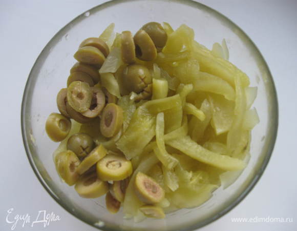 Соленые огурцы почистить, нарезать тонкой соломкой. Оливки, фаршированные каперсами, нарезать.