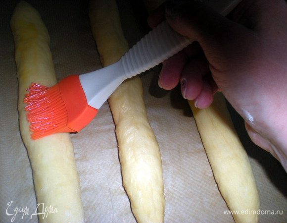 Смазать разболтанным с солью яйцом два раза.Я сначала промазала все булки,затем вернуласьк первой и опять прошлась кисточкой по всем.