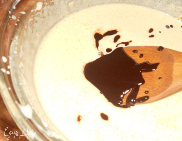 В желтки  небольшими порциями вводить растопленный шоколад и очень аккуратно перемешивать до однородной консистенции.