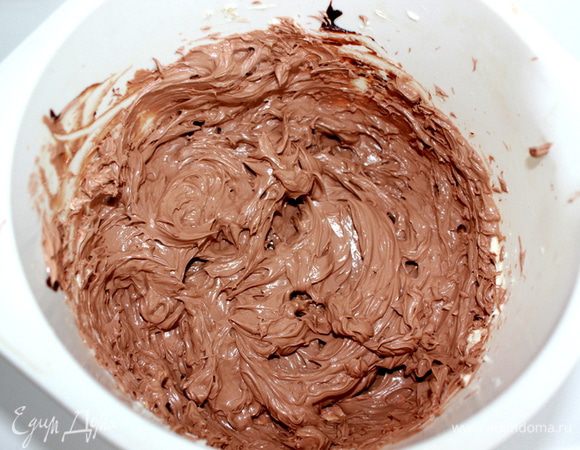 Добавляйте понемногу шоколадную смесь. Тщательно взбивайте. Влейте коньяк и ваниль, взбейте еще раз. 