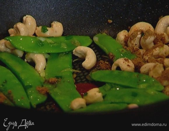 Разогреть в воке или глубокой сковороде ореховое масло, выложить орехи, лук, стручки гороха и обжаривать, помешивая, пока орехи не станут золотистыми, затем посыпать китайской смесью специй и перемешать.