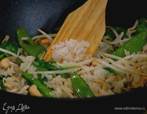 Выложить в сковороду отваренный рис, затем влить коньяк, перемешать и дать алкоголю выпариться.