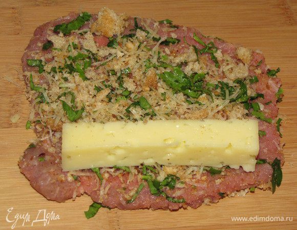 На каждый ломтик положить по одному брусочку твердого сыра.Свернуть их рулетиками и скрепить деревянными шпажками.  У меня брусочки оказались слишком длинными, поэтому часть сыра при запекании вытекла.