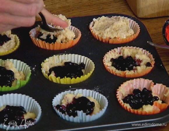 Формочки для маффинов смазать растительным маслом и заполнить тестом на 1/3 объема, сверху в каждую форму добавить по 1 ч. ложке джема, затем разложить оставшееся тесто так, чтобы джем оказался внутри маффинов.