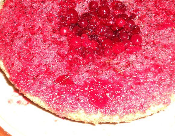 Корж разрезать на двое, один корж промазать половиной проваренной клюквой, во втором корже вырезать серединку.
